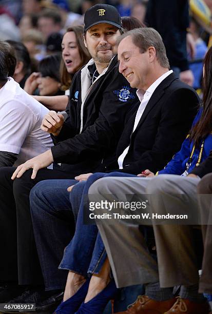 Owner Joe Lacob of the Golden State Warriors sits with professional poker player Phil Hellmuth during an NBA basketball game against the Charlotte...