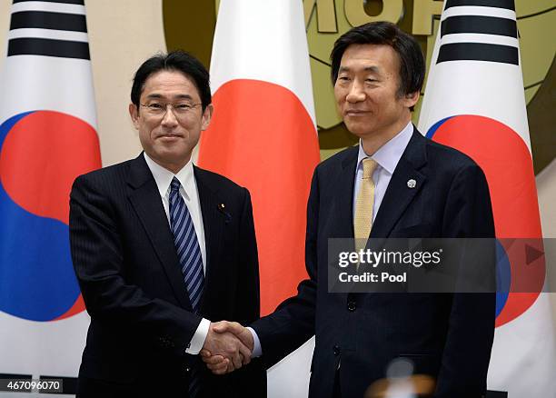 Japanese Foreign Minister Fumio Kishida shakes hands with South Korean Foreign Minister Yun Byung-Se during their meeting at foreign ministry on...