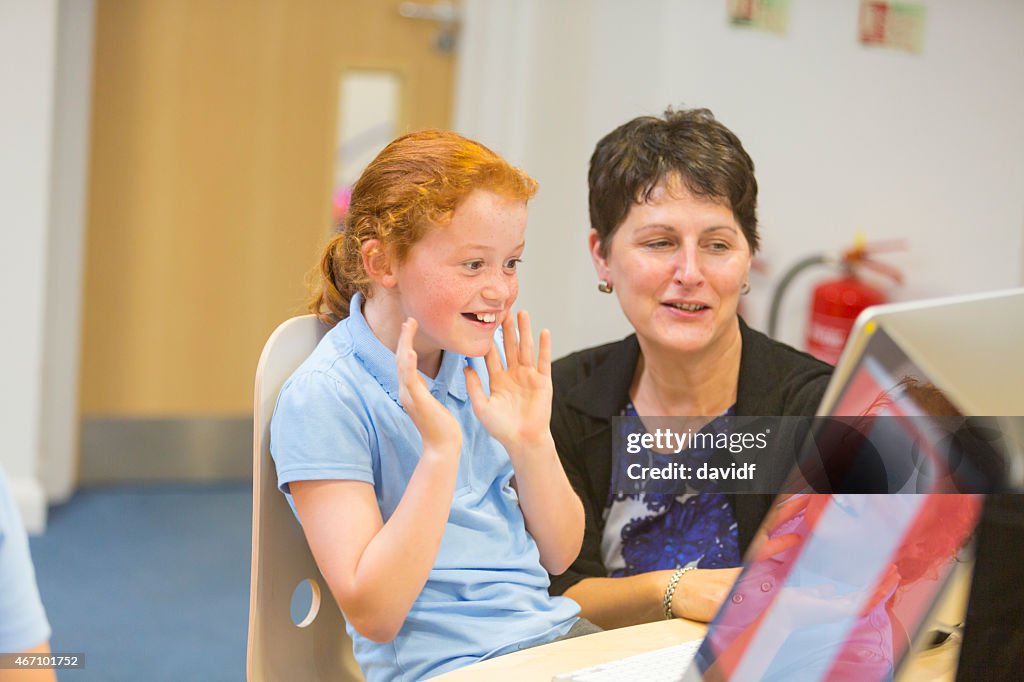 Young Girl In The Classroom With a Computer