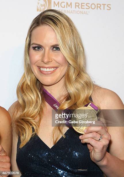 Olympic rower Esther Lofgren holds up her Olympic Medal as she arrives at the "One Night For ONE DROP" blue carpet event at 1 OAK Nightclub at The...