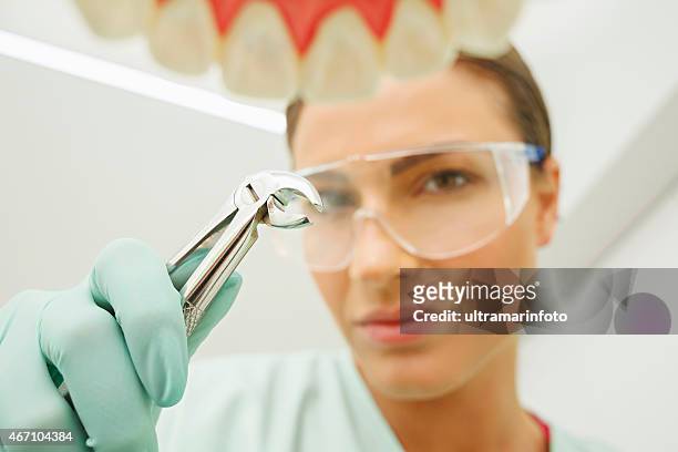 dentistry tooth  extraction   dentist working  dental tooth  extraction forceps - extraction forceps stockfoto's en -beelden