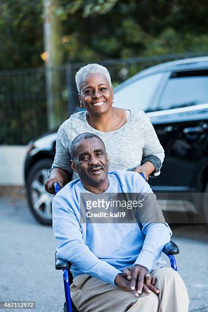 desativado idoso em cadeira de rodas com sua esposa dedicado - placa de deficiente físico imagens e fotografias de stock