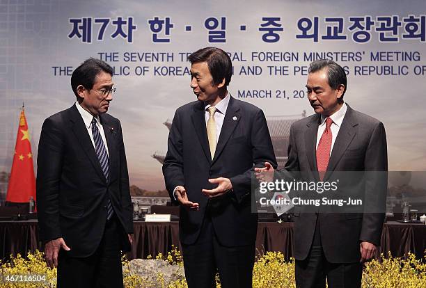 Japanese Foreign Minister Fumio Kishida, South Korean Foreign Minister Yun Byung-Se and Chinese Foreign Minister Wang Yi shakes hands befire their...