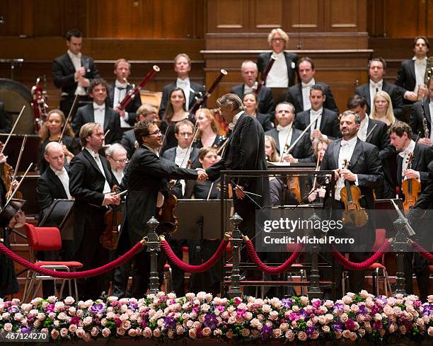 Latvian conductor Mariss Jansons thanks the first violinist after his final concert with the Royal Concertgebouw Orchestra on March 20, 2015 in...