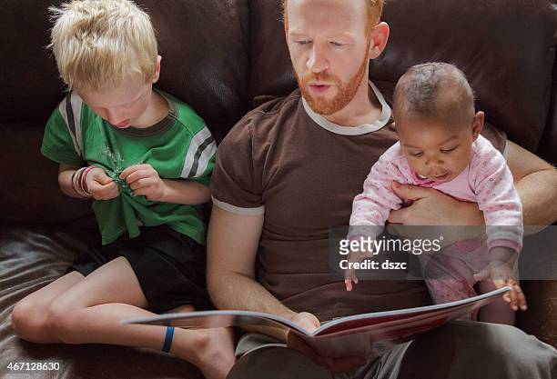 Father reading bedtime stories to his children. Multi-ethnic group