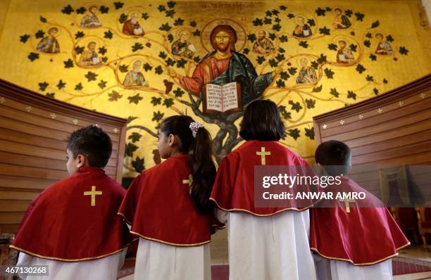 Iraqi Christian children, who fled the violence in the Nineveh province, attend a mass with their mothers at a chuch in Dekwaneh, east of the...