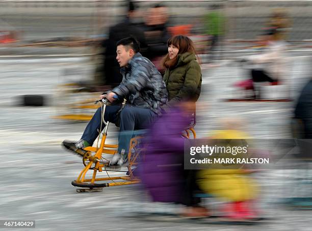 Chinese visitors enjoy sledding and skating on the partially frozen Houhai Lake during the Lunar New Year holiday in Beijing on February 6, 2014....