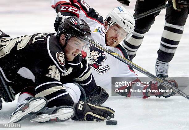 Garrett Mitchell of the Hershey Bears tries to keep the puck away from an incoming Alex Bolduc of the Portland Pirates during the first period of an...