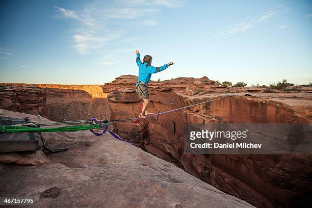 guy walking on a line over a canyon in moab. - herausforderung stock-fotos und bilder