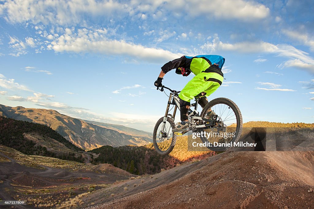 Guy juming with a mountain bike at sunrise.