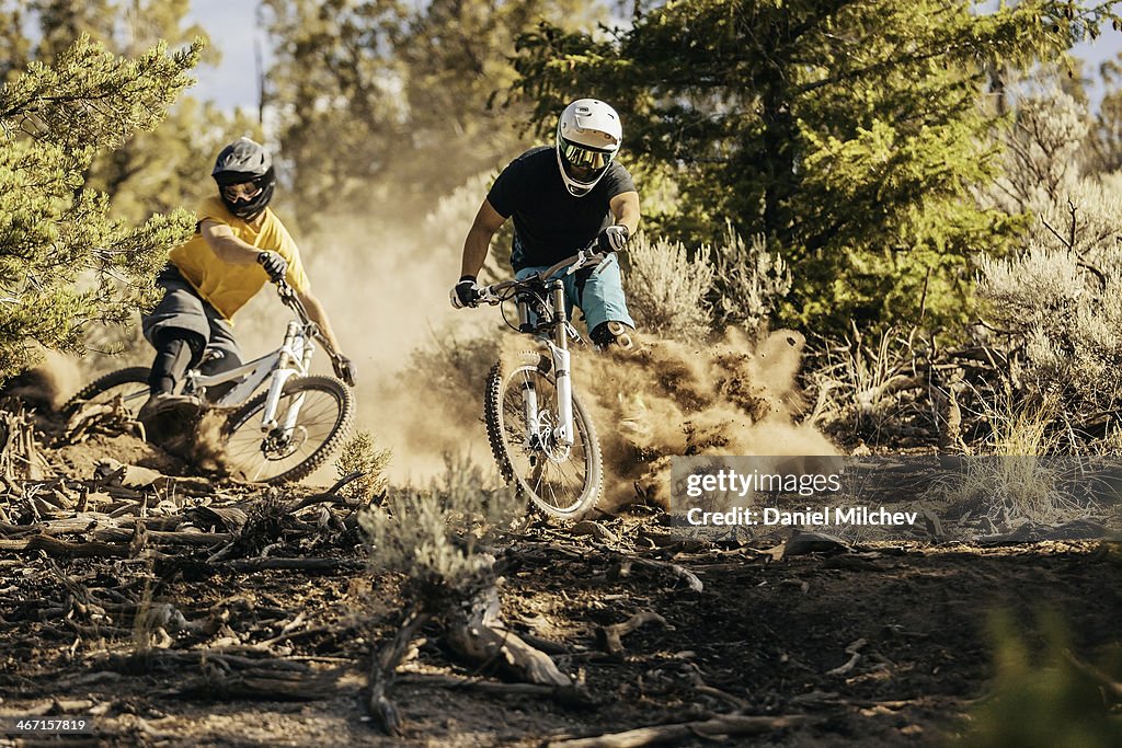 Friends riding bikes on a dusty trail.