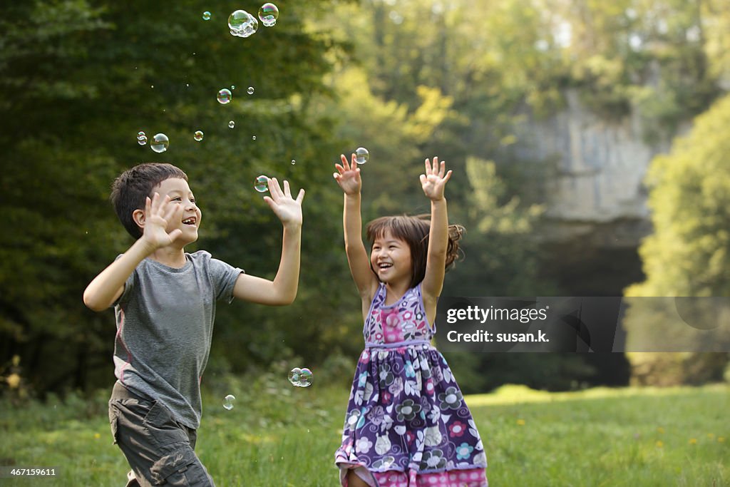 Siblings on bubble joy in the nature