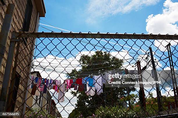 view through wire fence to laundry on clothes line - maschendrahtzaun stock-fotos und bilder