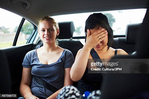 two women in backseat of car - cultura orientale photos et images de collection