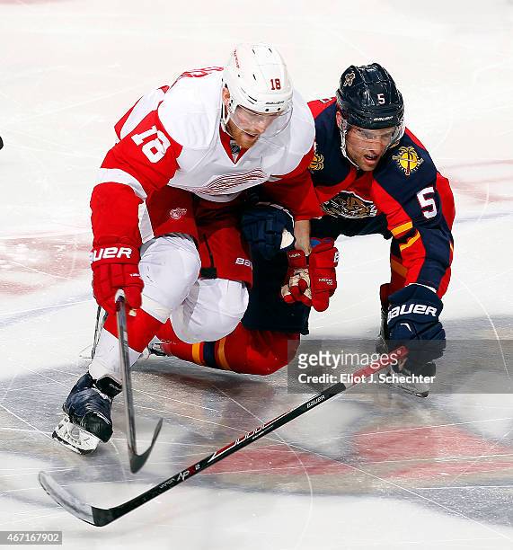 Aaron Ekblad of the Florida Panthers skates for possession against Joakim Andersson of the Detroit Red Wings at the BB&T Center on March 19, 2015 in...