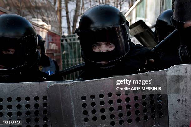 Riot police stand guard as anti-government protesters march around the Ukrainian Parliament in Kiev on February 6, 2014. Ukraine's unrest erupted in...