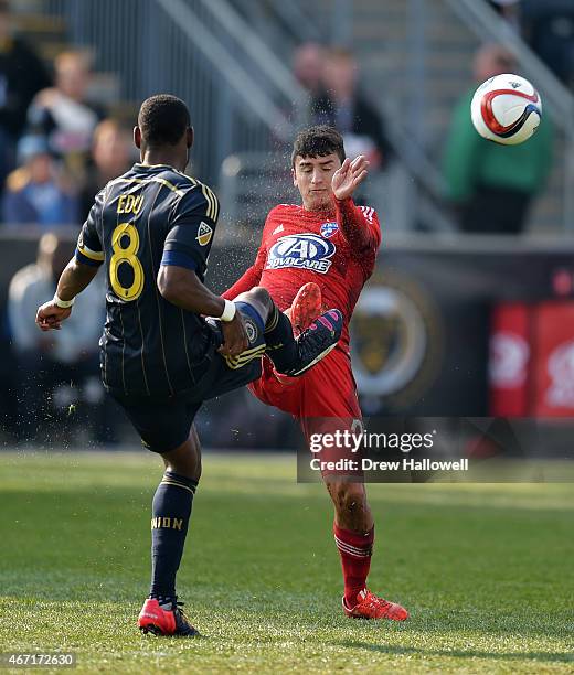 Maurice Edu of Philadelphia Union kicks the ball along with some mud and water past Mauro Diaz of FC Dallas at PPL Park on March 21, 2015 in Chester,...