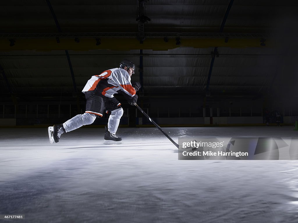 Male Ice Hockey Player skating with puck