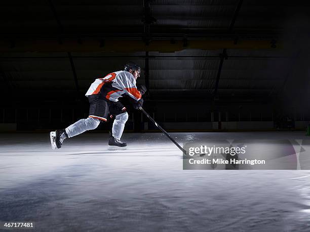 male ice hockey player skating with puck - pista di pattinaggio su ghiaccio foto e immagini stock