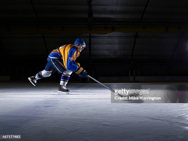 male ice hockey player skating with stick - hockey stick fotografías e imágenes de stock