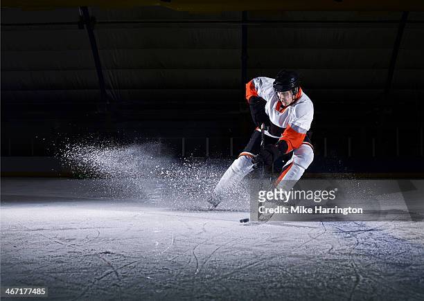 male ice hockey player taking puck - ice hockey stock-fotos und bilder