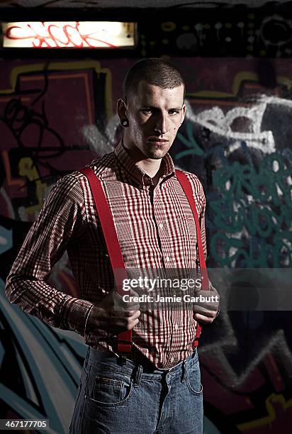 portrait of male skinhead against graffitied wall - skinhead stock-fotos und bilder