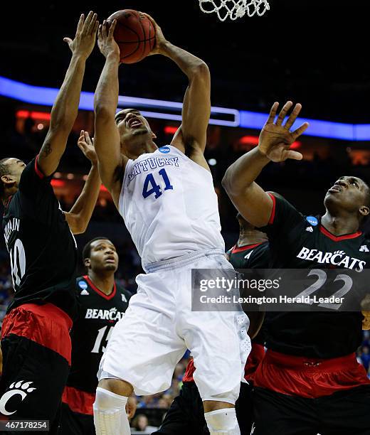 Kentucky's Trey Lyles puts up a shot between Cincinnati's Troy Caupain and Coreontae DeBerry in the third round of the NCAA Tournament on Saturday,...