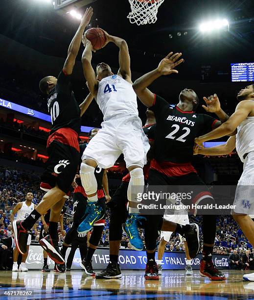 Kentucky's Trey Lyles puts up a shot between Cincinnati's Troy Caupain and Coreontae DeBerry in the third round of the NCAA Tournament on Saturday,...