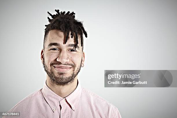 a portrait of a male wearing a pink shirt smiling - locs hairstyle stock pictures, royalty-free photos & images