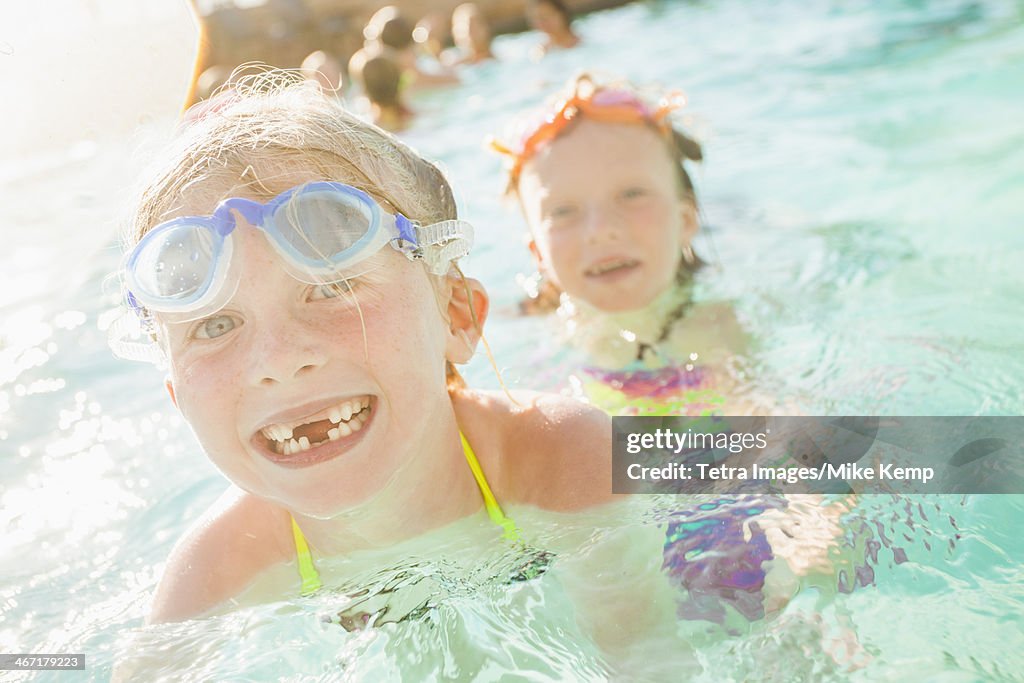 USA, Utah, Park City, Girlfriends (4-5, 8-9) playing in swimming pool