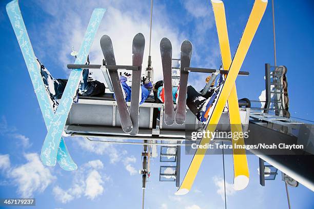 usa, montana, whitefish, family of skiers on ski lift seen from below - whitefish montana stockfoto's en -beelden
