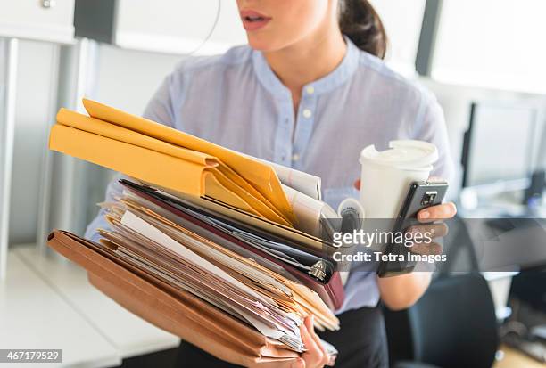 usa, new jersey, jersey city, business woman holding stack of documents in office - workload stock-fotos und bilder