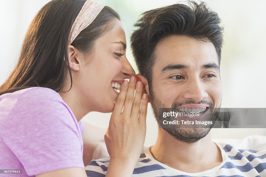 USA, New Jersey, Jersey City, Woman whispering to man's ear