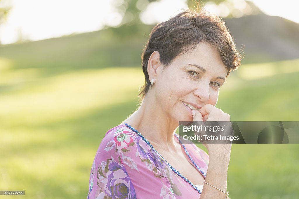 USA, New York State, New York City, Portrait of mature woman smiling outdoors