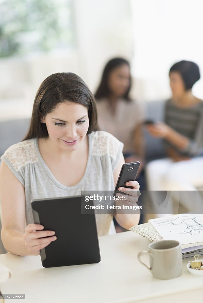 USA, New Jersey, Jersey City, Woman using digital tablet and mobile phone