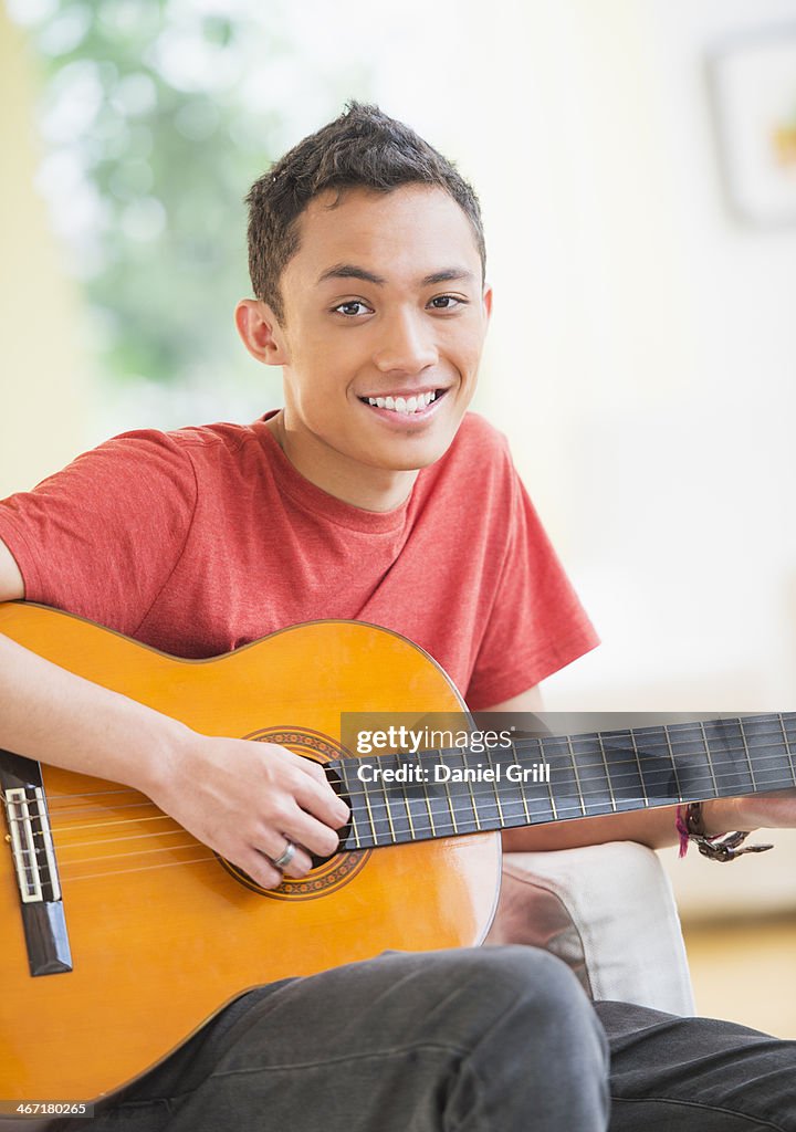 USA, New Jersey, Jersey City, Young man playing guitar