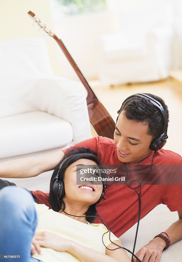 USA, New Jersey, Jersey City, Young woman and man listening music with headphones on