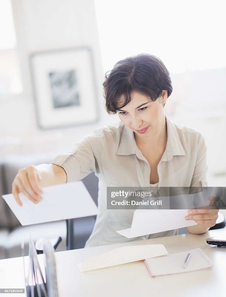 USA, New Jersey, Jersey City, Woman doing paperwork at home office