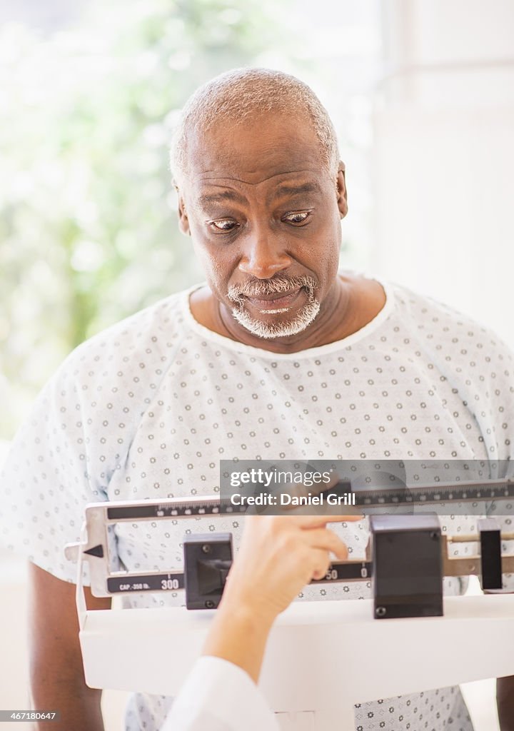 USA, New Jersey, Jersey City, Shocked man on weight scale