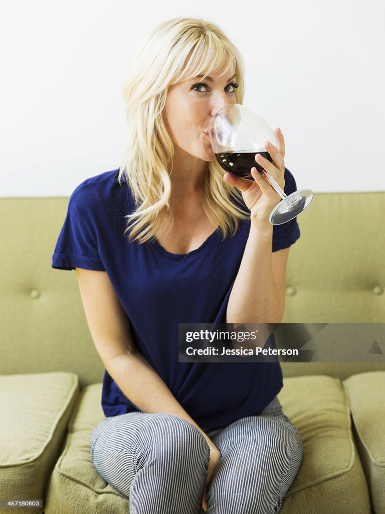 Woman relaxing on sofa and drinking wine