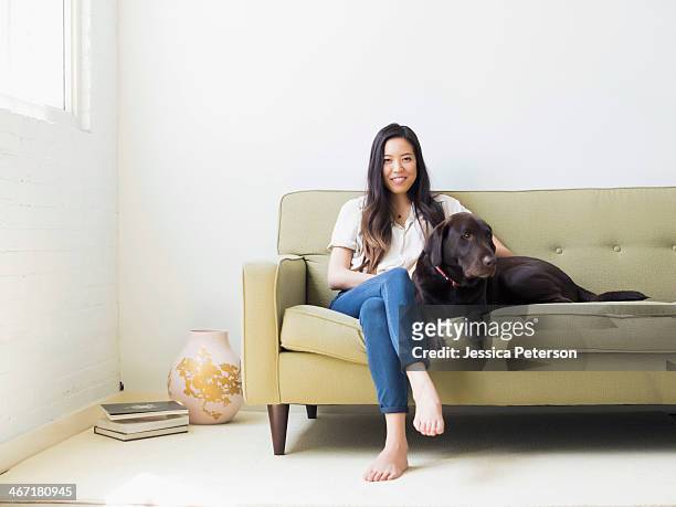 portrait of woman with dog sitting on sofa - dog portrait stock pictures, royalty-free photos & images