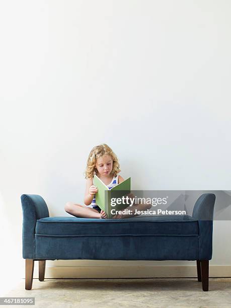 girl (4-5) sitting on bench and reading book - 5 years stock pictures, royalty-free photos & images