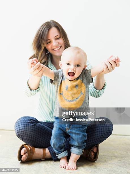 studio portrait of mother holding baby boy (6-11 months) - baby studio stock-fotos und bilder