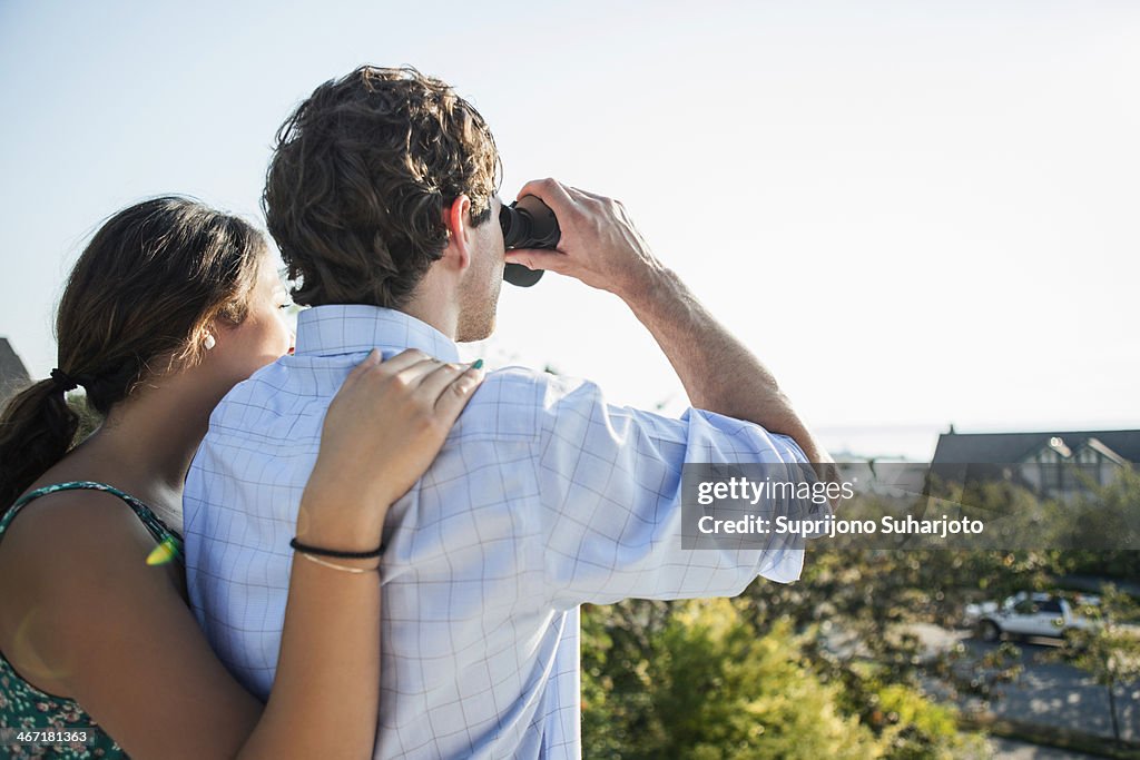 USA, Washington, Everett, Rear view of couple, man looking through binoculars
