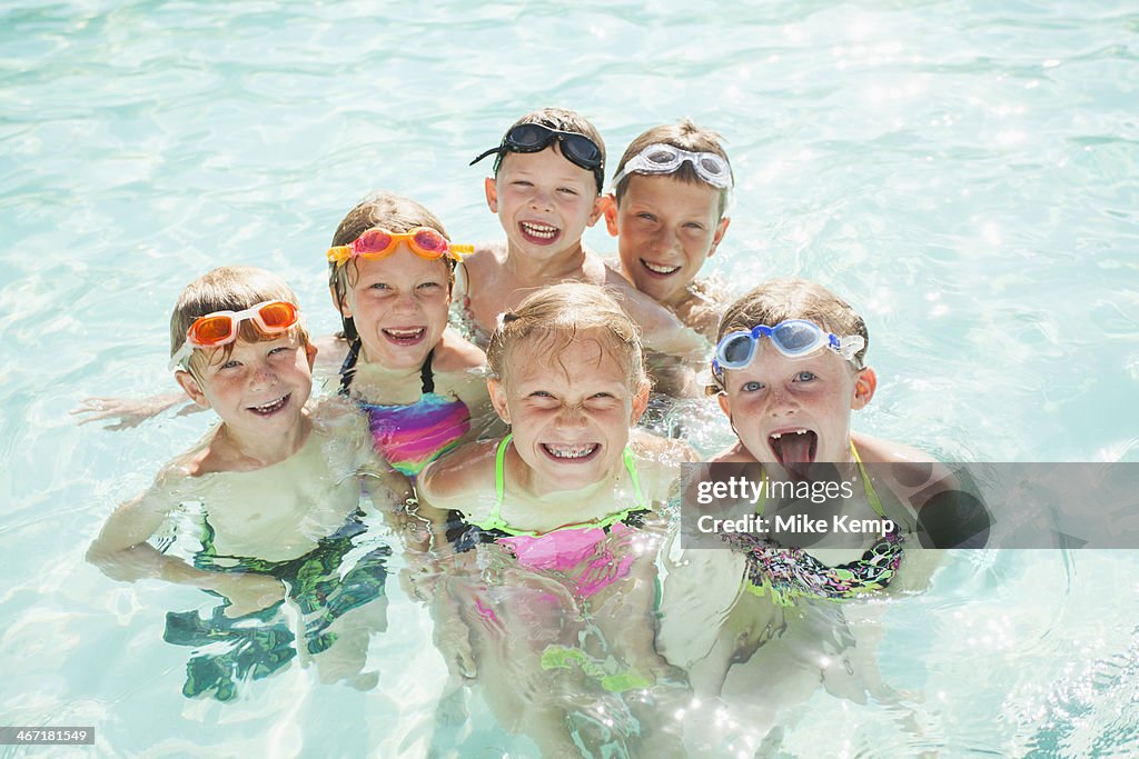 USA, Utah, Park City, Children (4-5, 2-3, 8-9, 10-11, 18-23 months) playing in swimming pool