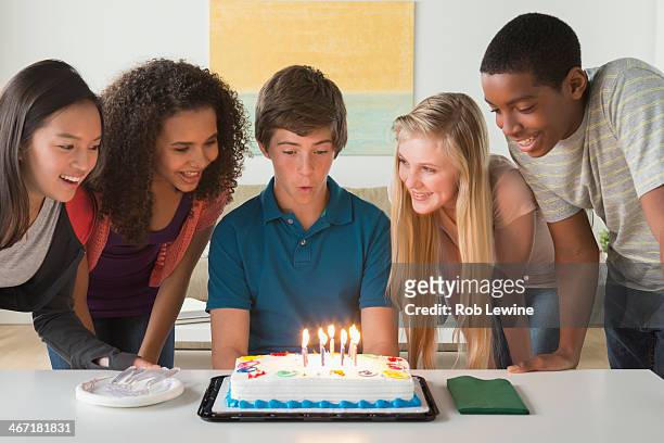 usa, california, los angeles, children (12-13,14-15,16-17) blowing candles on birthday cake - boys birthday stock pictures, royalty-free photos & images