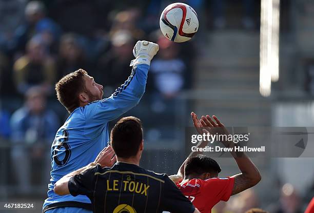 Chris Seitz of FC Dallas punches the ball away from Sebastien Le Toux of Philadelphia Union and teammate Moises Hernandez at PPL Park on March 21,...