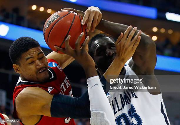 Kyle Washington of the North Carolina State Wolfpack and Daniel Ochefu of the Villanova Wildcats go after the ball in the first half during the third...