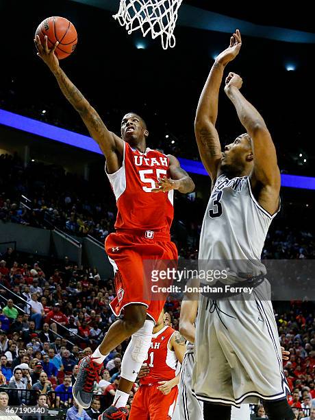 Delon Wright of the Utah Utes goes up against Mikael Hopkins of the Georgetown Hoyas in the first half during the third round of the 2015 NCAA Men's...