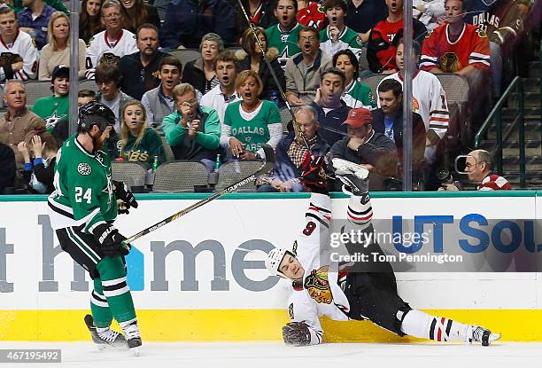 Jordie Benn of the Dallas Stars checks Andrew Shaw of the Chicago Blackhawks into the boards in the second period at American Airlines Center on...